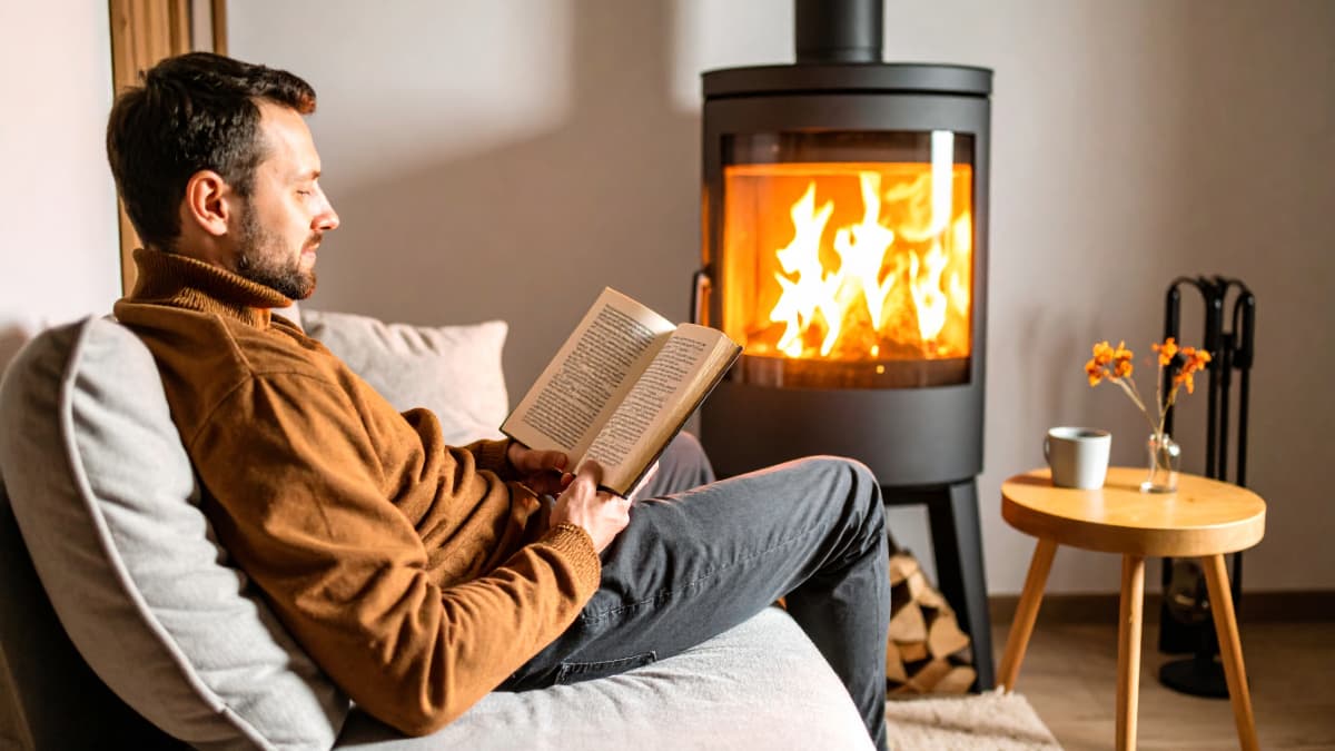 homme qui lit devant son poêle